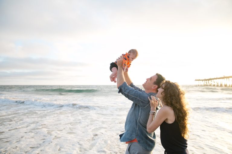dad, mom and baby at beach