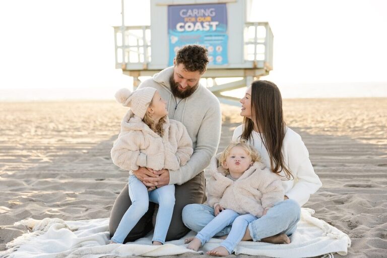 family sitting on the beach looking at each other