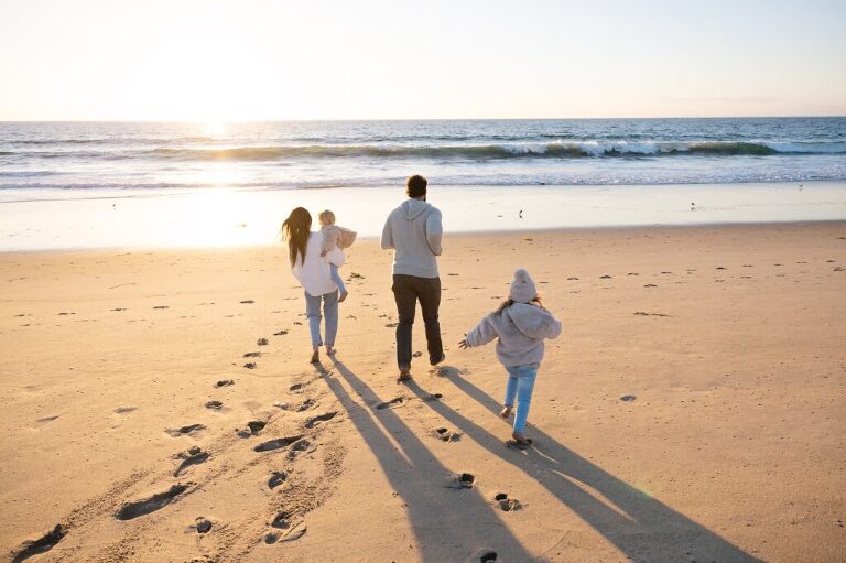 family running towards the water on the beach